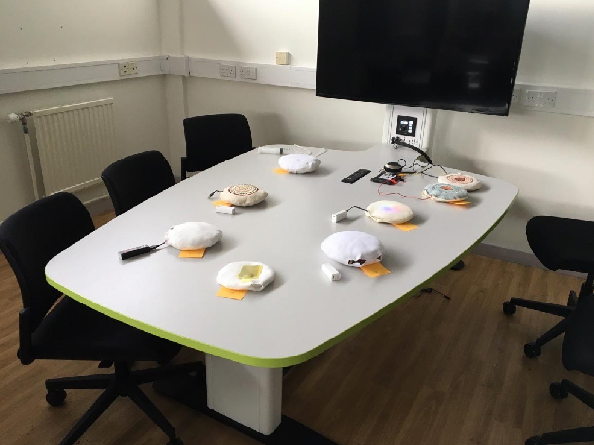 Photo of a table on which eight spherical cushion prototypes are laid out for participants to interact with.