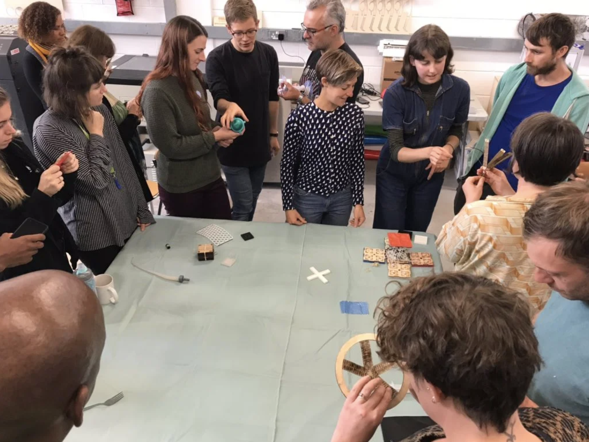 Photo of people looking at and discussing different objects at an outreach event